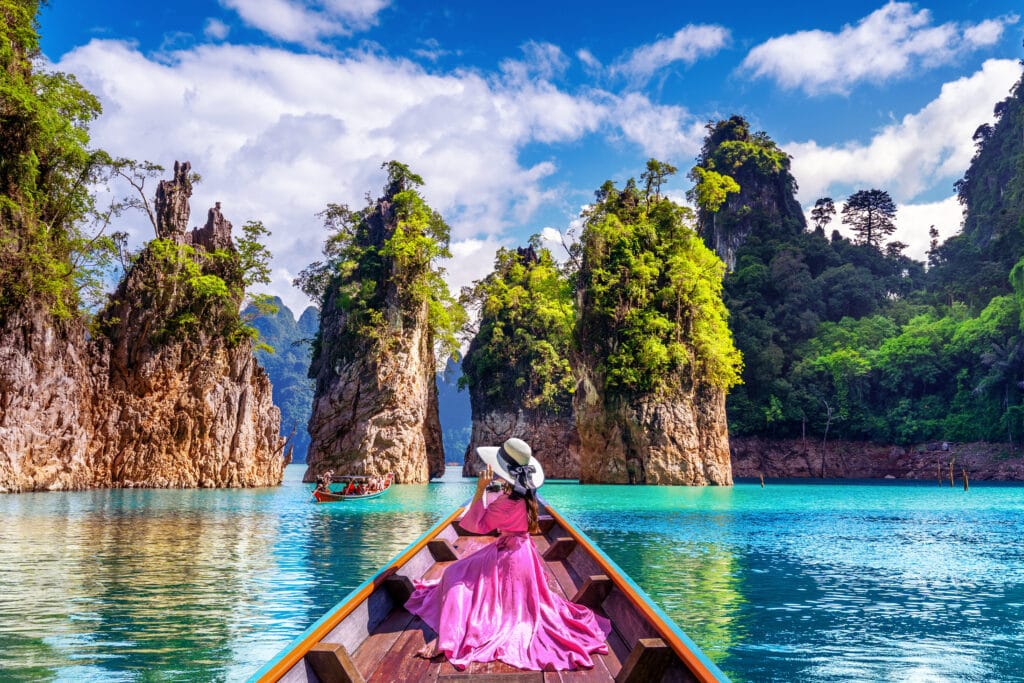 Beautiful girl sitting on the boat and looking to mountains in R