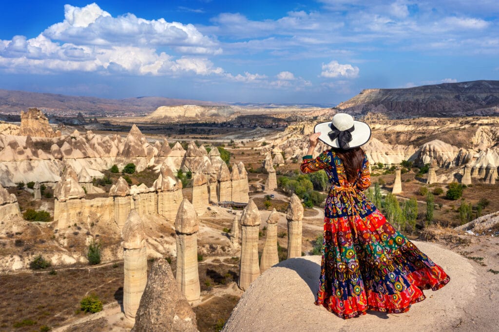 Woman in Bohemian dress standing on Love Valley in Cappadocia, T